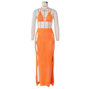 Detail view of bright orange crochet knit bikini top and high-waisted hollow out maxi skirt