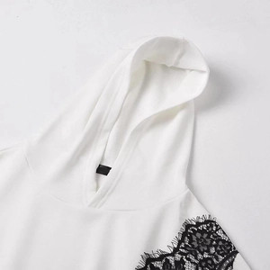Gros plan sur un sweat à capuche blanc oversize avec dentelle florale noire sur les épaules