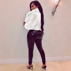 Detail of white faux fur jacket paired with glossy black latex pants on a model