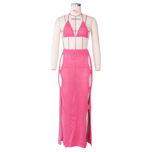 Detail of hot pink crochet knit two-piece set featuring cutout long skirt and halter top