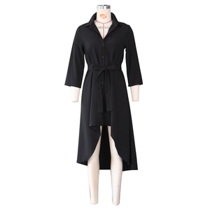 Detail of black shirt dress featuring button front, waist tie, and asymmetrical hemline