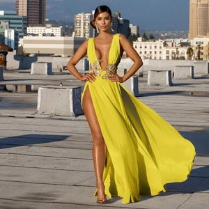 Détail de la robe de soirée jaune avec broderies florales à la taille et fente haute