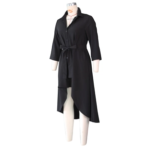 Detail of black irregular hem shirt dress with waist belt and turn-down collar
