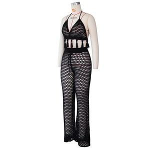 Detailed view of black crochet halter top with fringe and matching mesh wide-leg trousers