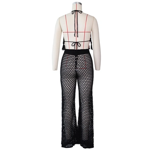 Detail of black crochet knit set featuring a halter backless top and fringed hemline