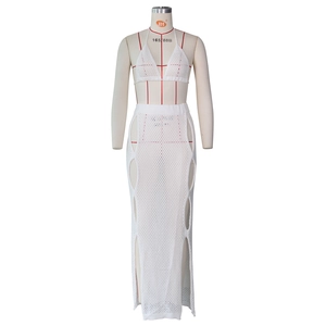 Detail of white crochet knit beach set showing intricate hollow mesh texture and fabric