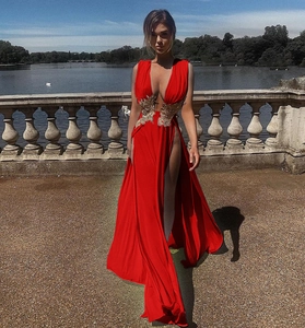 Détail d'une robe de soirée rouge avec broderies baroques dorées et fentes hautes