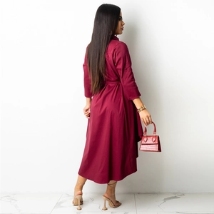 Detail view of burgundy asymmetrical long-sleeved shirt dress with waist tie and turnover collar