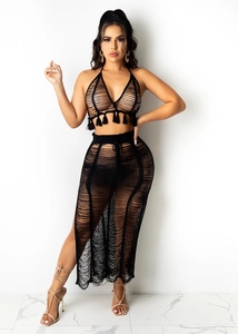Detail of black crochet two-piece beach set featuring tassel hem and hollow-out knit design