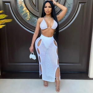 White crochet two-piece set featuring halter bikini top and cut-out long skirt for beachwear