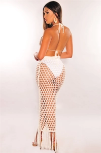 Détail d'une jupe de plage en crochet blanc avec maille ajourée et longues franges boho