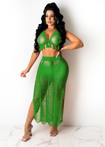 Detail of green knit beach set featuring fringe tassels and hollow-out mesh texture
