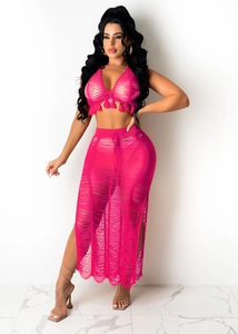 Detail of pink crochet two-piece set with halter top tassels and high slit maxi skirt