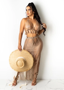 Detail of crochet knit beach set featuring fringe crop top and side slit maxi skirt