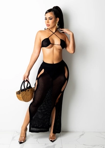 Detail of black crochet knit two-piece set featuring cutout maxi skirt and halter top