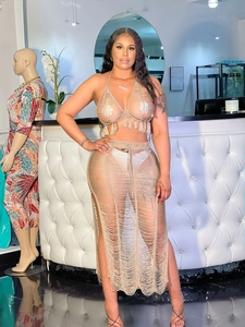 Detail of beige knit crochet beach set with halter fringe top and side slit maxi skirt