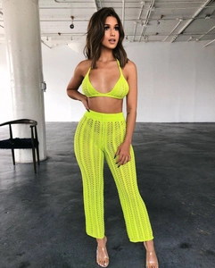 Detail of neon green crochet knit two-piece set featuring halter top and wide leg pants