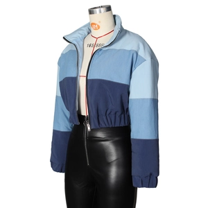 Detail view of a tri-color blue gradient cropped jacket with black faux leather pants