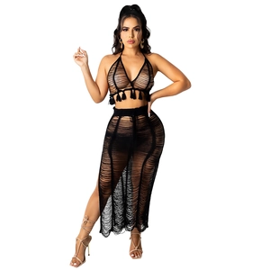 Women's black crochet knit two-piece beach set with fringe halter top and long slit skirt