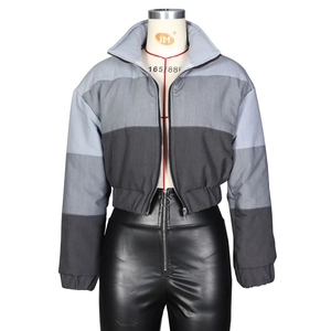 Detail of a color-blocked denim jacket with stand-up collar and metallic front zipper