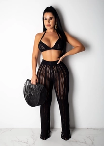 Detail of black crochet knit two-piece set featuring halter top and high-waist flared pants