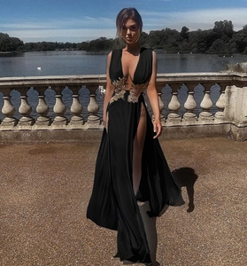 Détail de la broderie papillon dorée sur une robe de soirée noire élégante à fente haute