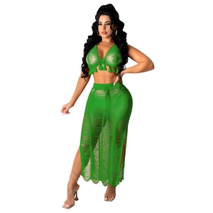 Detail showing emerald green crochet knit texture and fringe hem of the beach set