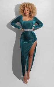 Detailed shot of emerald green velvet dress with square neck and sparkling rhinestone belt