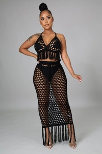 Détail d'un ensemble de plage au crochet noir avec haut à pompons et jupe longue en maille