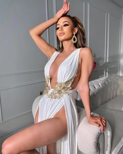 Détail d'une robe de soirée en soie blanche avec décolleté en V et broderie florale dorée