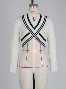 Detail of white cropped knit sweater with black V-neck stripes on a mannequin