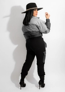 Detailed side view of a cropped two-tone quilted jacket and cargo joggers on a model