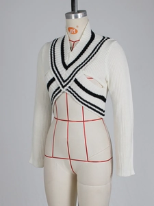 Detail of cream V-neck knit cardigan featuring black stripes and cross-over design