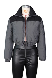 Detail view of gray and black puffer jacket with high-waisted matte leather trousers