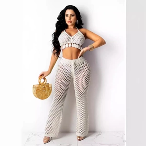 White crochet knit two-piece set with fringe halter top and high-waist mesh flare pants