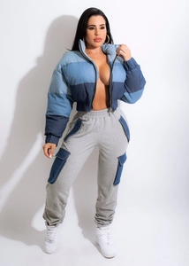 Detail of color-block denim puffer jacket with high collar and blue pocket flaps