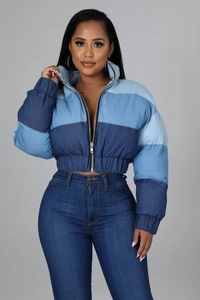 Detail of blue gradient patchwork denim jacket featuring standing collar and metal zipper