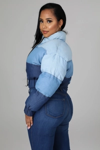 Detail of blue gradient patchwork quilted puffer jacket with zip-up stand collar