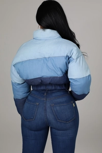 Back view of a women's denim puffer jacket featuring a trendy gradient patchwork design