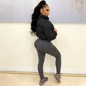 Detailaufnahme einer schwarzen Pufferjacke und grauen Ripp-Leggings an einem Modemodell