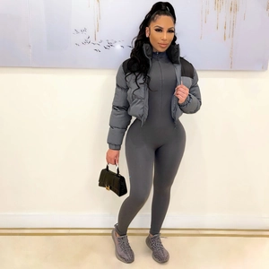 Women's dark grey cropped puffer jacket and ribbed bodysuit with black handbag