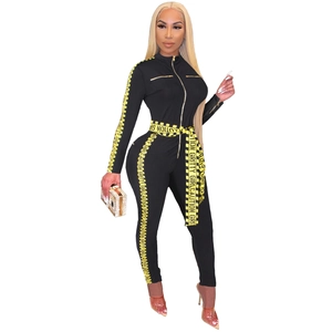 Detailed view of black sexy jumpsuit featuring yellow Caution and Gritty Girl print stripes