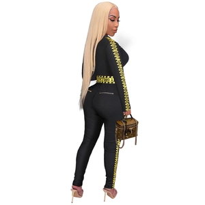 Detail view of black women's jumpsuit with yellow caution tape lettering and gold back zipper