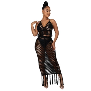Détail de l'ensemble deux pièces en maille crochet noire avec haut à pompons et jupe ajourée