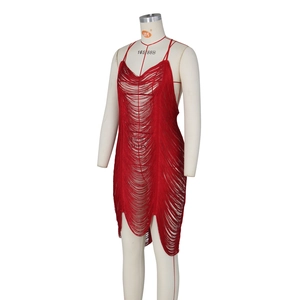 Detailed close-up of red fringe dress with hollow knit pattern and tassel hem design