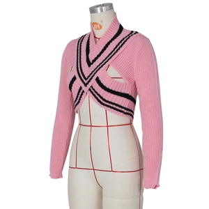 Detailed view of pink knitted shrug with black stripes and cross-front design on a mannequin
