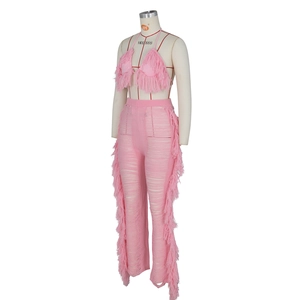 Rosafarbenes Strickset bestehend aus Neckholder-Quastentop und Fransenhose mit Rissen