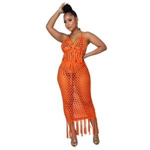 Détail d'un ensemble deux pièces en crochet orange avec haut licou et jupe évidée à franges