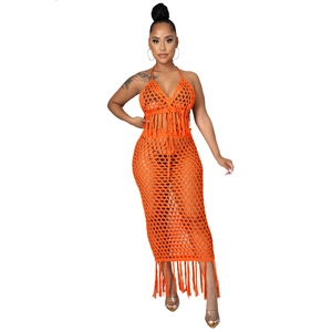 Détail de l'ensemble crochet orange avec haut licou à pompons et jupe longue en maille ajourée
