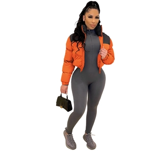 Detail of orange and black puffer jacket paired with a grey bodysuit and handbag